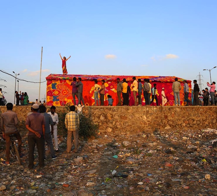 Olek (birthday April 4), the crochet graffiti artist standing on top of homeless shelter she has just decorated -- with lots of help -- in Delhi