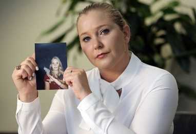 Virginia Giuffre holds a photograph of her younger self. Photo by Emily Michot 